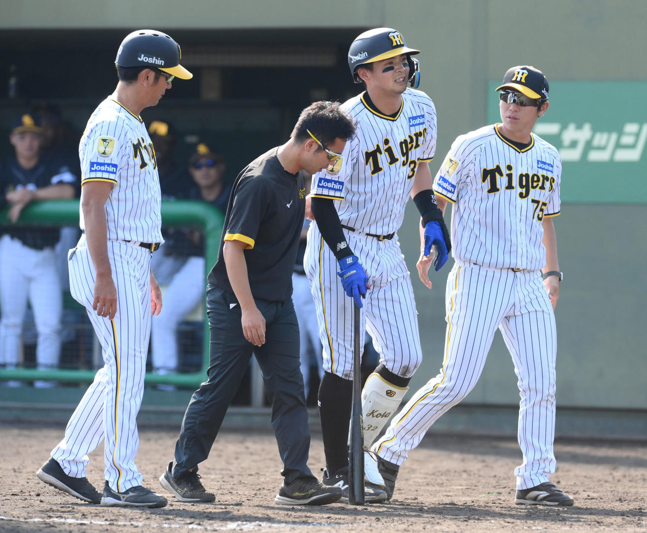 ウエスタン・リーグ阪神対ソフトバンク　9回裏阪神無死、阪神井上（右から2人目）は、左内ももに自打球を当てて治療に向かう（撮影・滝沢美穂子）