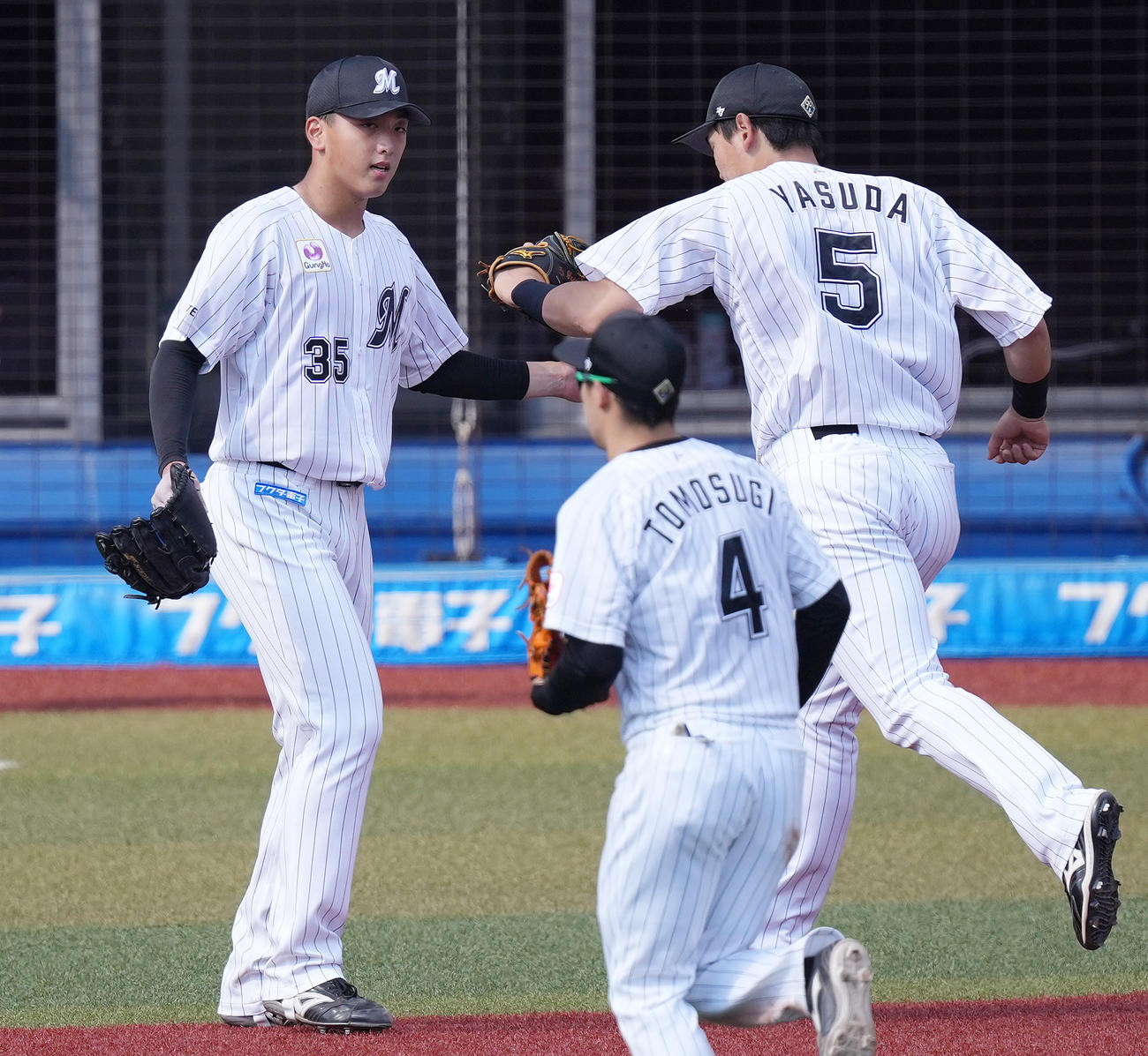 ロッテ対阪神　5回表まで無失点に抑え、安田（右）とタッチを交わすロッテ田中晴（左）（撮影・鈴木みどり）