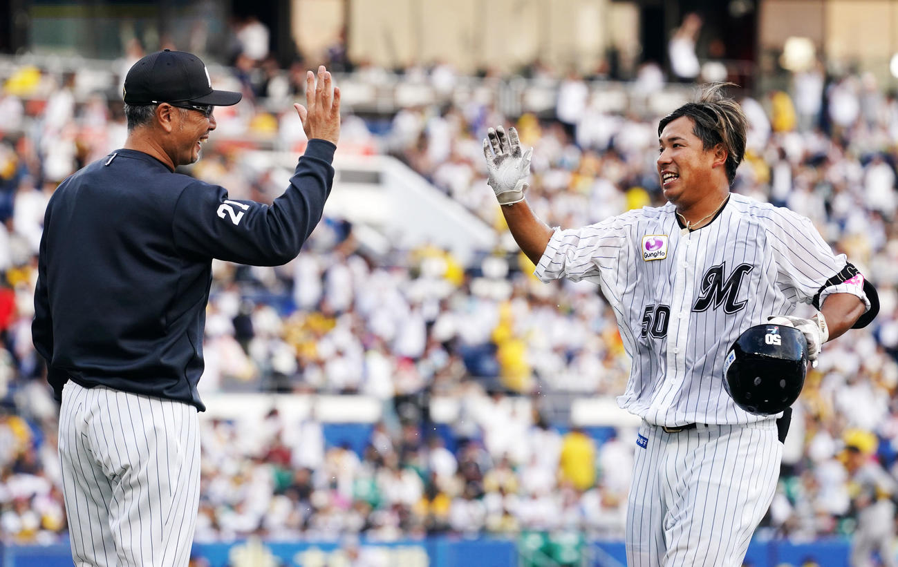 ロッテ対阪神　ロッテに勝利しタッチを交わすロッテ吉井監督（左）と愛斗（撮影・横山健太）