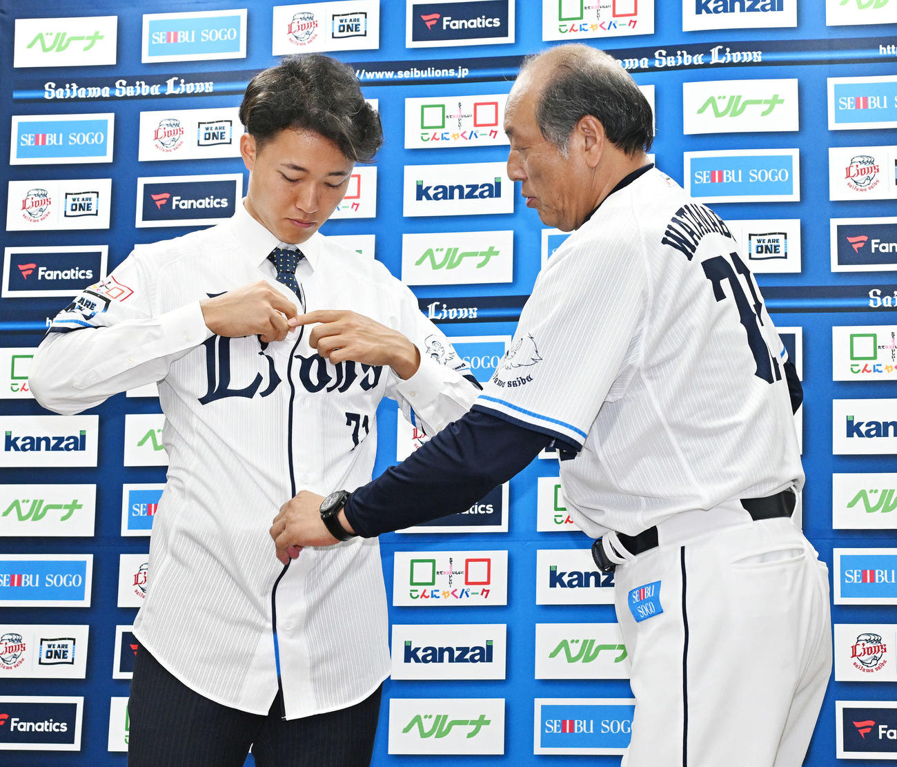 支配下登録された西武菅井（左）は渡辺GM兼監督代行とユニホームを着る（撮影・滝沢徹郎）