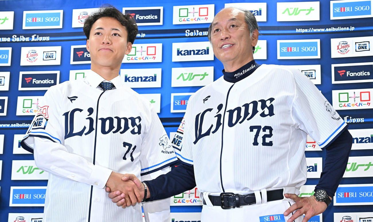 支配下登録された西武菅井（左）は渡辺GM兼監督代行と記念撮影する（撮影・滝沢徹郎）