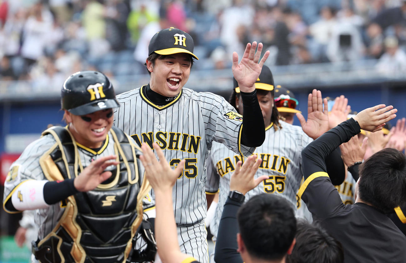 ロッテ対阪神　完封勝利で連敗を止め、ナインらとタッチを交わして喜ぶ梅野（左端）と才木ら（撮影・前田充）