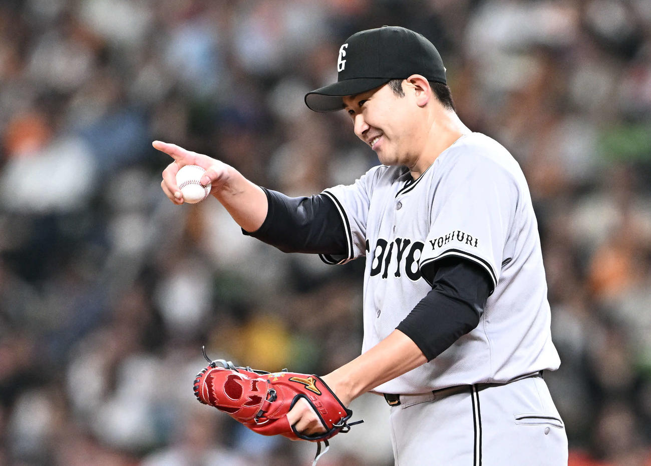 西武対巨人　6回裏、巨人先発の菅野は好守を見せた三塁手岡本和を指さす（撮影・滝沢徹郎）