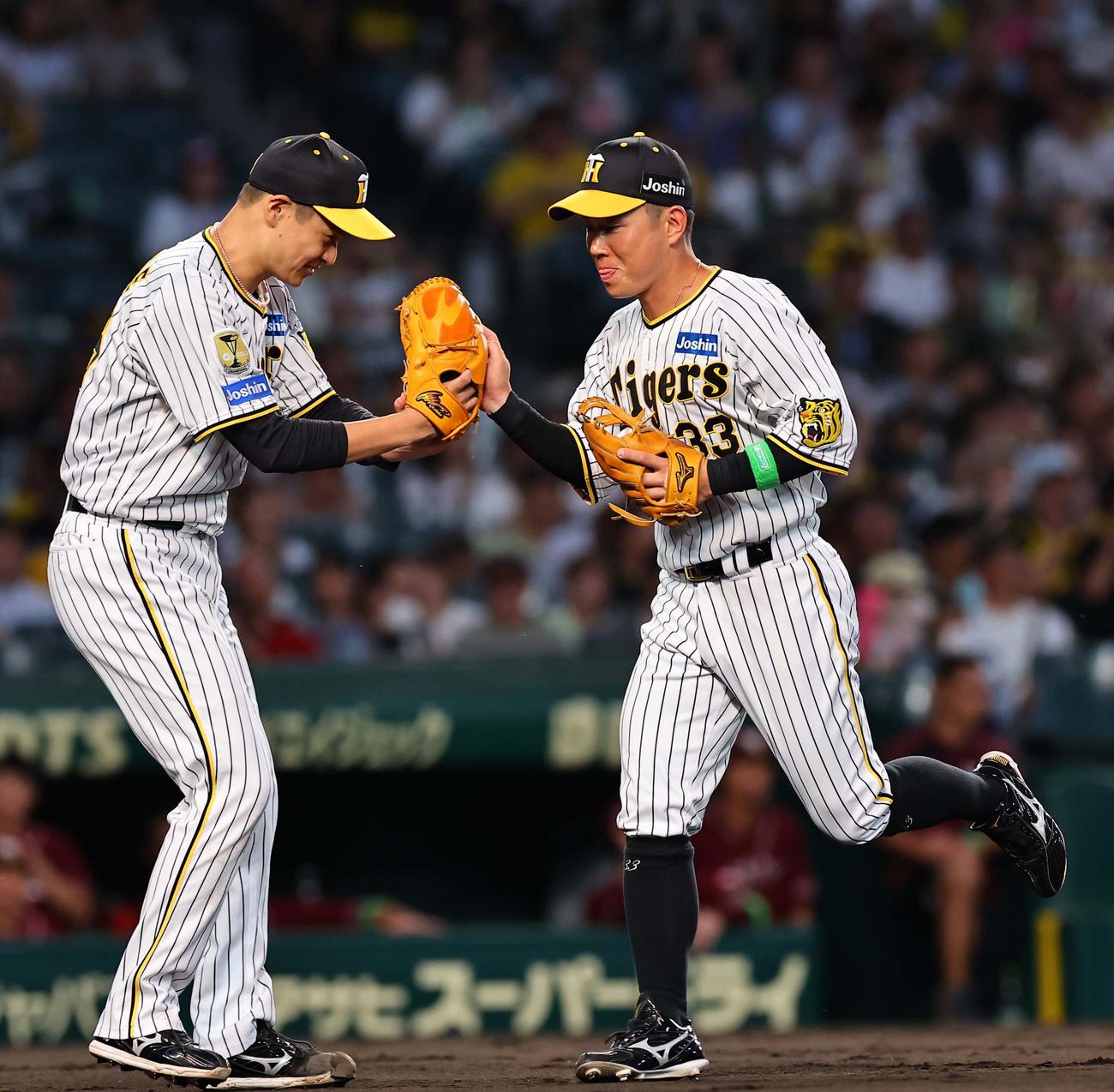 阪神対楽天　5回表楽天2死一、二塁、村林の三直をさばいた糸原（右）を出迎える大竹（撮影・上田博志）