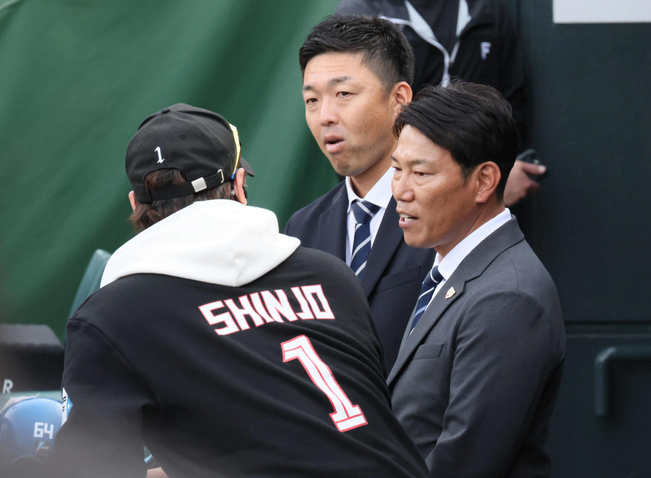 広島対日本ハム　試合前練習中、球場に訪れた侍ジャパン井端監督（右）は新庄監督と話し合う。後ろは吉見侍ジャパンコーチ（撮影・加藤孝規）