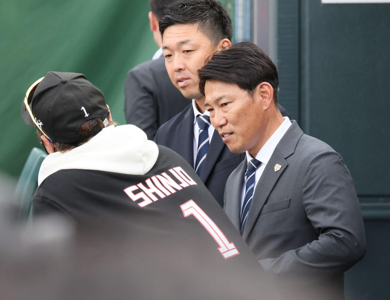 広島対日本ハム　試合前練習中、球場に訪れた侍ジャパン井端監督（右）は新庄監督と話し合う。後ろは吉見侍ジャパンコーチ（撮影・加藤孝規）