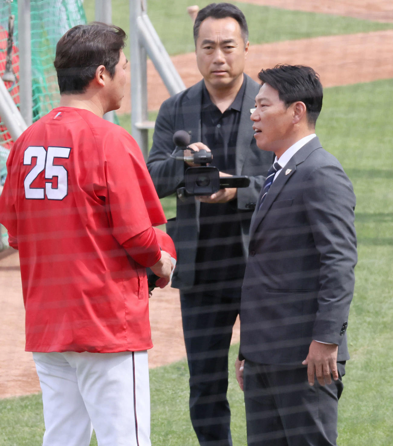 広島対日本ハム　試合前練習中、球場に訪れた侍ジャパン井端監督（右）は新井監督と話し合う（撮影・加藤孝規）