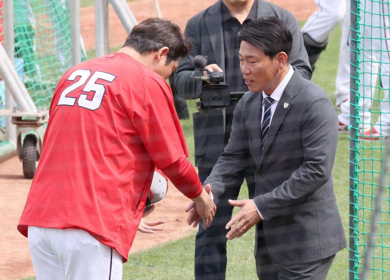 広島対日本ハム　試合前練習中、球場に訪れた侍ジャパン井端監督（右）は新井監督と握手（撮影・加藤孝規）