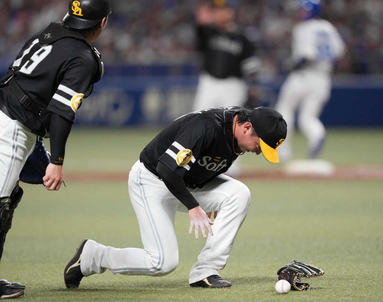 中日対ソフトバンク　3回裏中日2死、福永の打球を腰に当てうずくまる東浜（右）（撮影・森本幸一）
