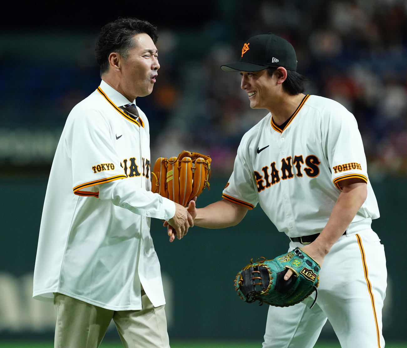 巨人対ロッテ　ファーストピッチを務め捕手の小林と握手を交わす元木氏（撮影・たえ見朱実）