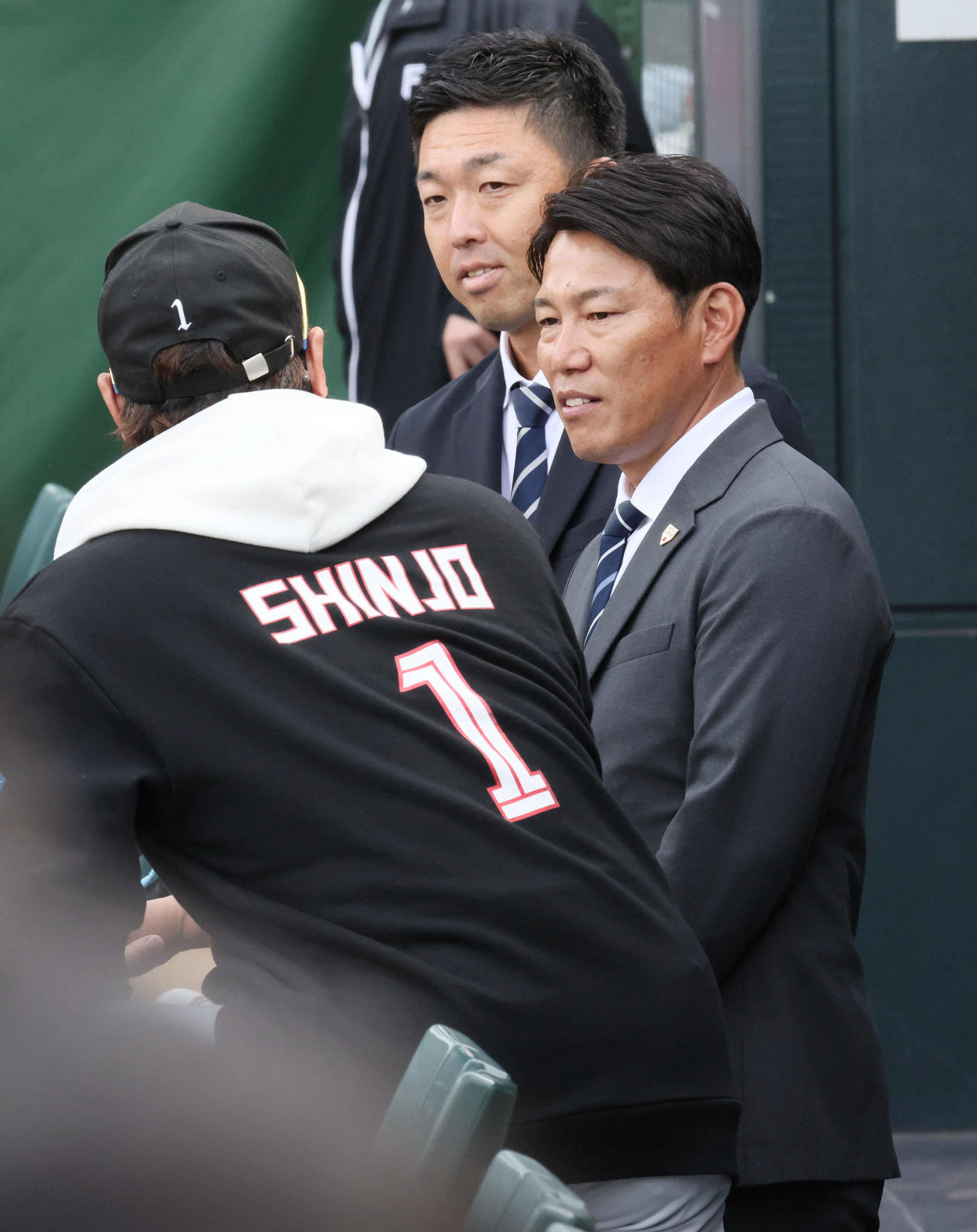 広島対日本ハム　試合前練習中、球場に訪れた侍ジャパン井端監督（右）は新庄監督と話し合う。後ろは吉見侍ジャパンコーチ（撮影・加藤孝規）