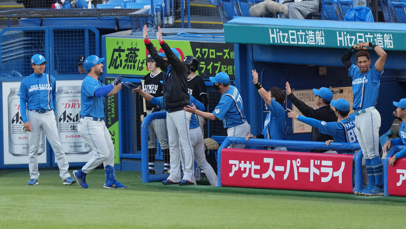 ヤクルト対日本ハム　1回表日本ハム2死、左越えにソロ本塁打を放ち、新庄監督（左から4人目）らに迎えられるマルティネス（左から2人目）（撮影・菅敏）