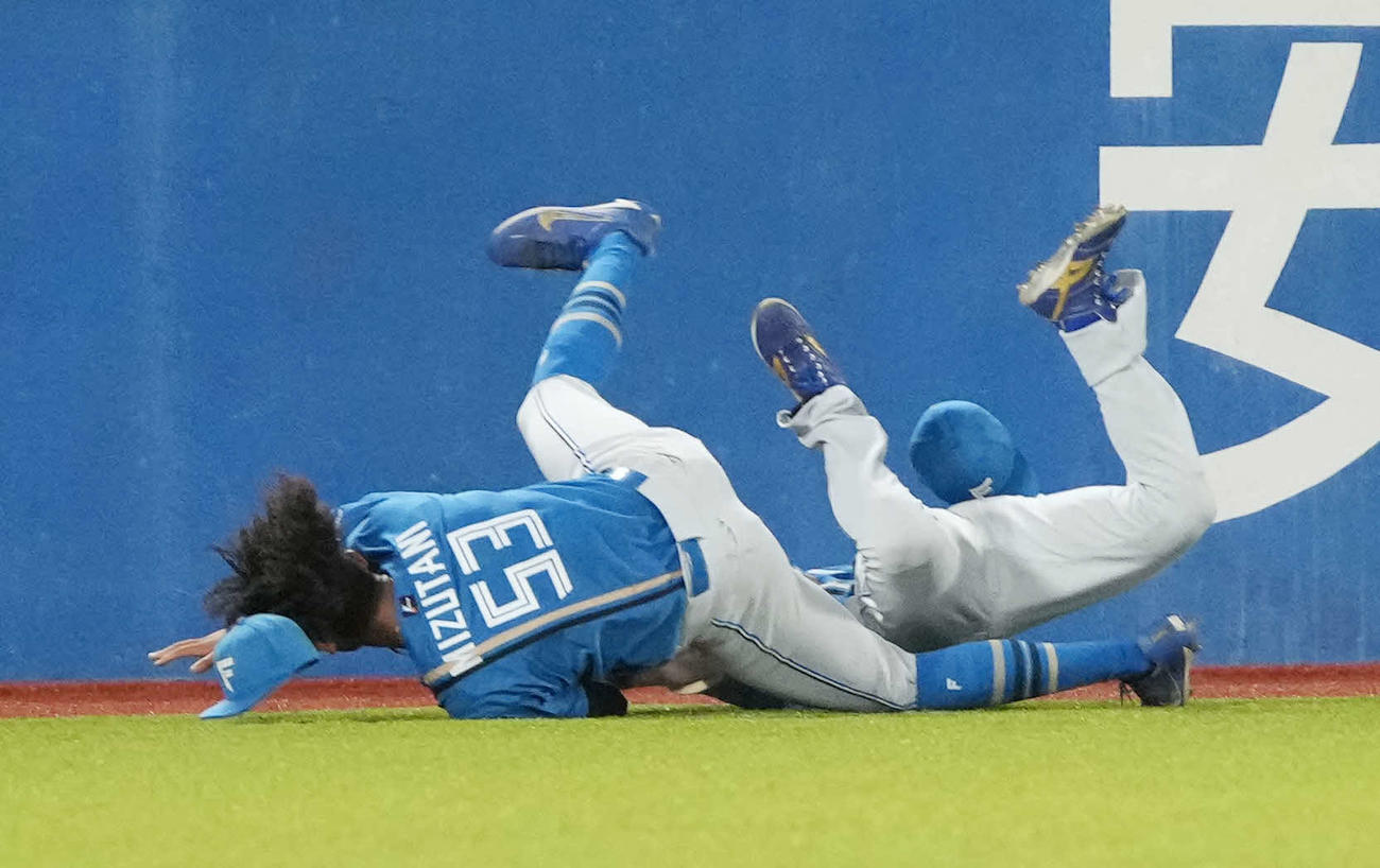 ヤクルト対日本ハム　4回裏ヤクルト無死、長岡の中飛を捕球した日本ハム松本剛中堅手（右）は水谷左翼手と激突し転倒。場内が一時騒然となったが両者とも無事に立ち上がった（撮影・小沢裕）