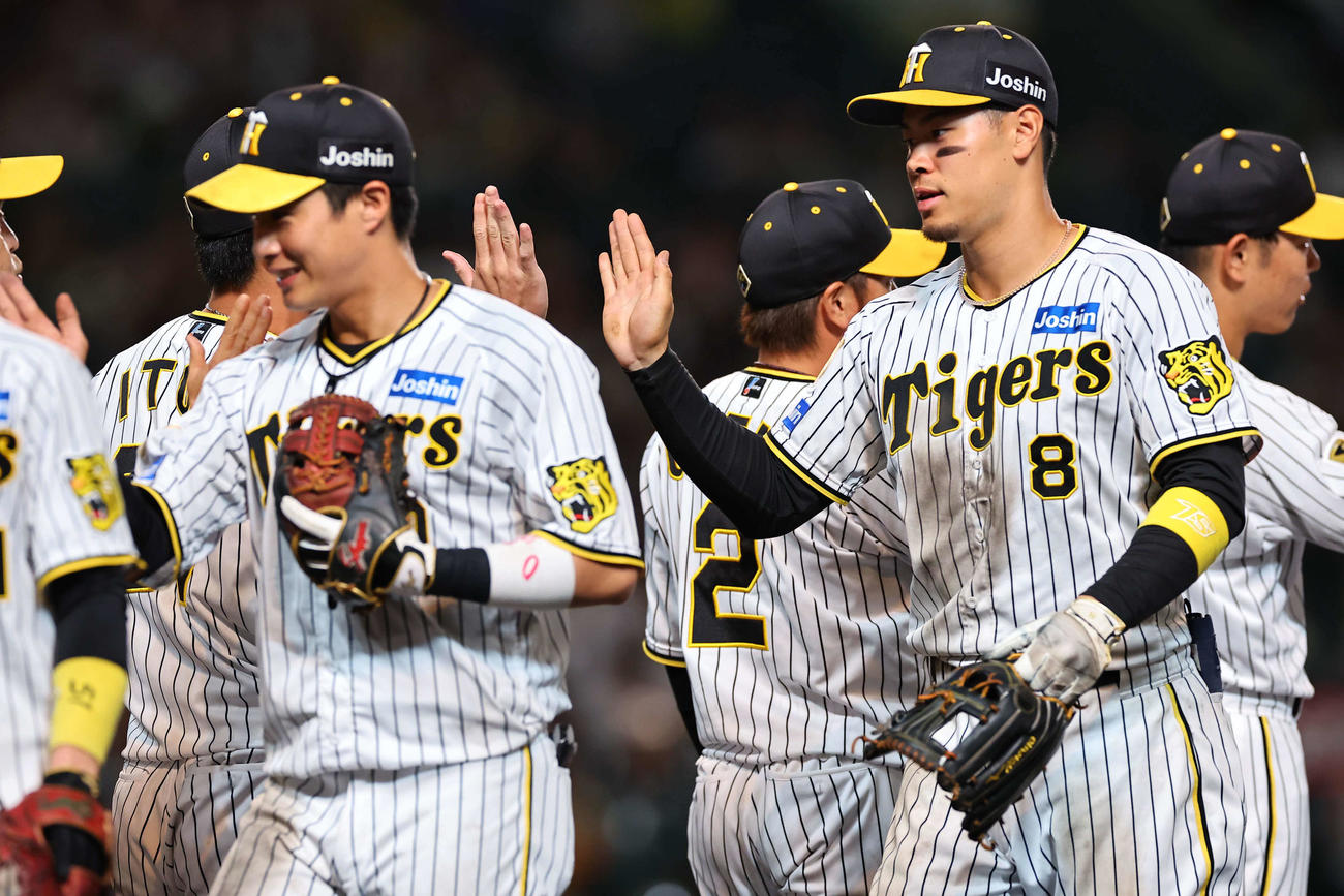 阪神対西武　佐藤輝（右）はナインとハイタッチして喜ぶ（撮影・上田博志）