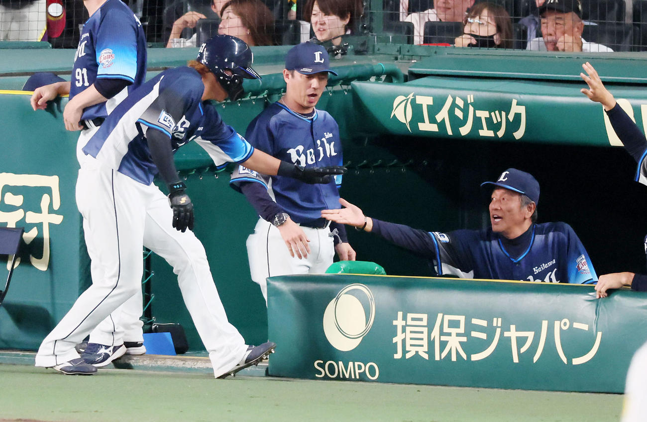 阪神対西武　5回表西武2死一、三塁、代打長谷川の左適時打で生還した三塁走者の西川（左）とタッチする渡辺監督代行（撮影・加藤哉）