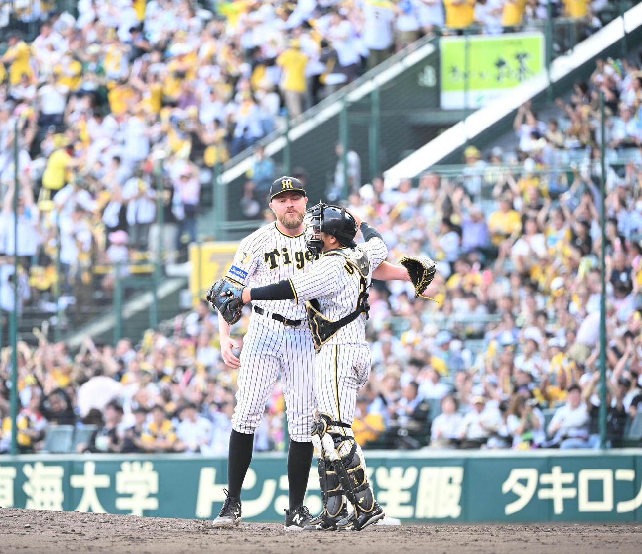 阪神対西武　1失点で完投勝利を飾ったビーズリーは捕手梅野（右）と抱き合って喜び合う（撮影・和賀正仁）