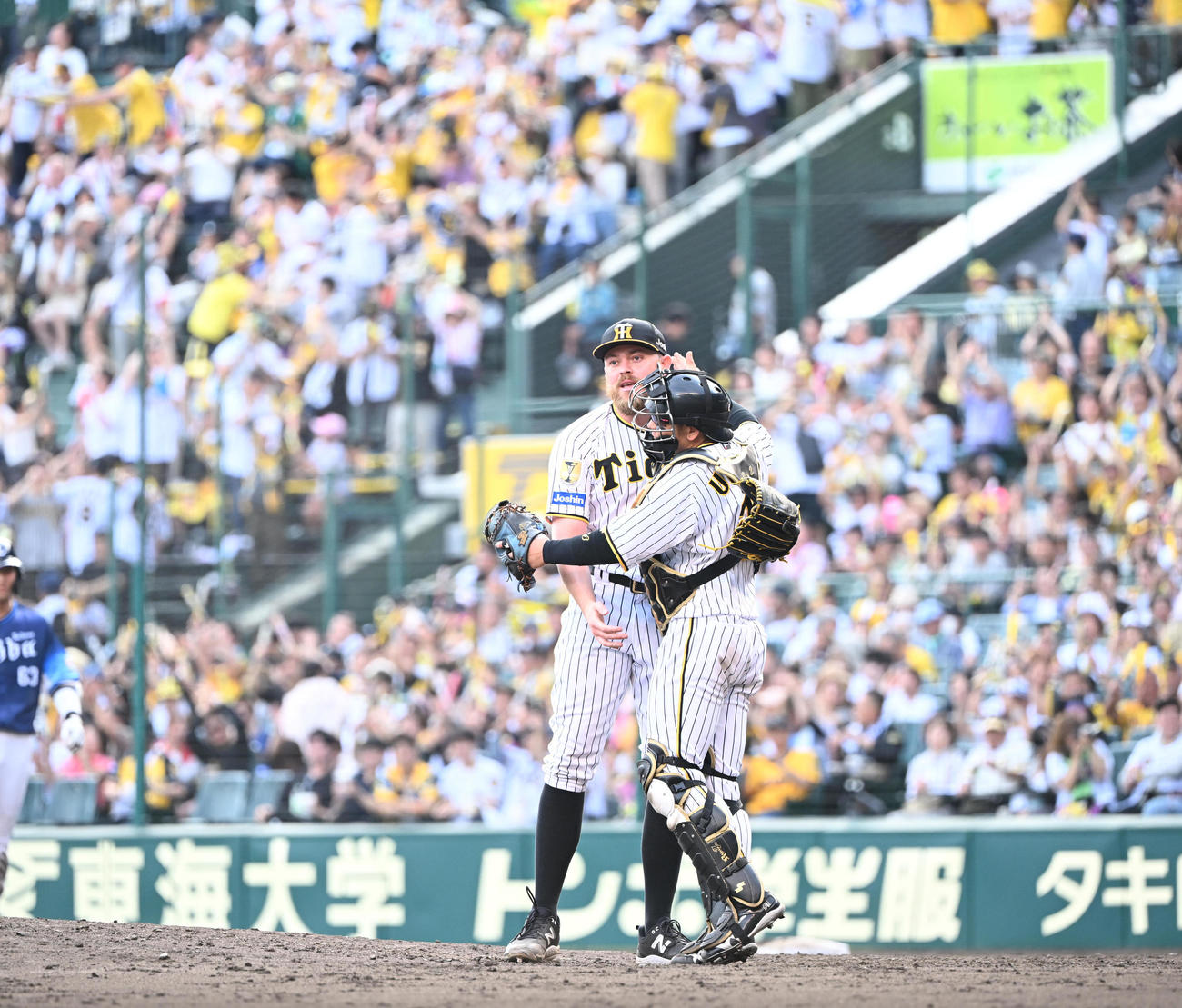 阪神対西武　1失点で完投勝利を飾ったビーズリーは捕手梅野（右）と抱き合って喜び合う（撮影・和賀正仁）