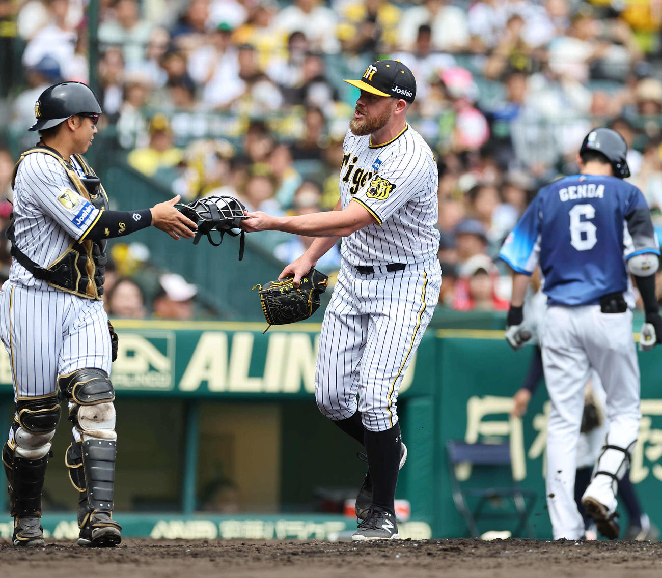 阪神対西武　3回表西武2死、源田を捕邪飛に打ち取ったビーズリー（中央）は梅野にマスクを手渡す（撮影・上田博志）