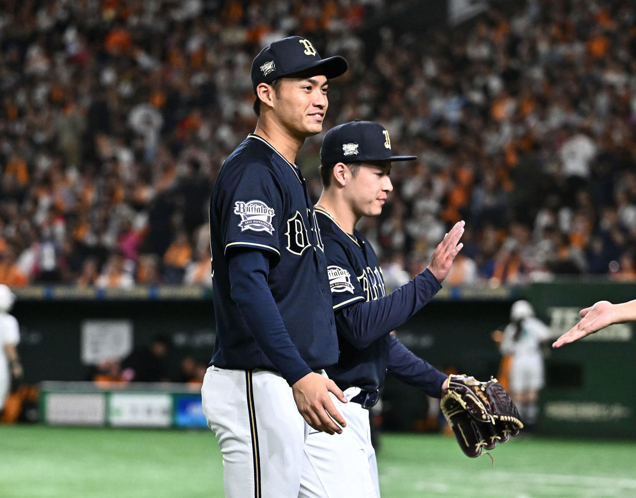 巨人対オリックス　6回裏を投げ終えたオリックス3番手の吉田（後方）を迎える佐藤（撮影・滝沢徹郎）