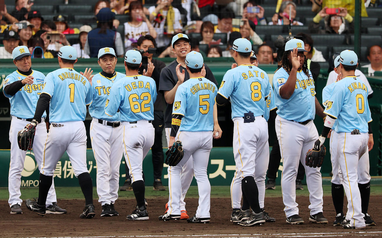 阪神対西武　西武に勝利しナインを出迎える才木。左は岡田監督（撮影・加藤哉）
