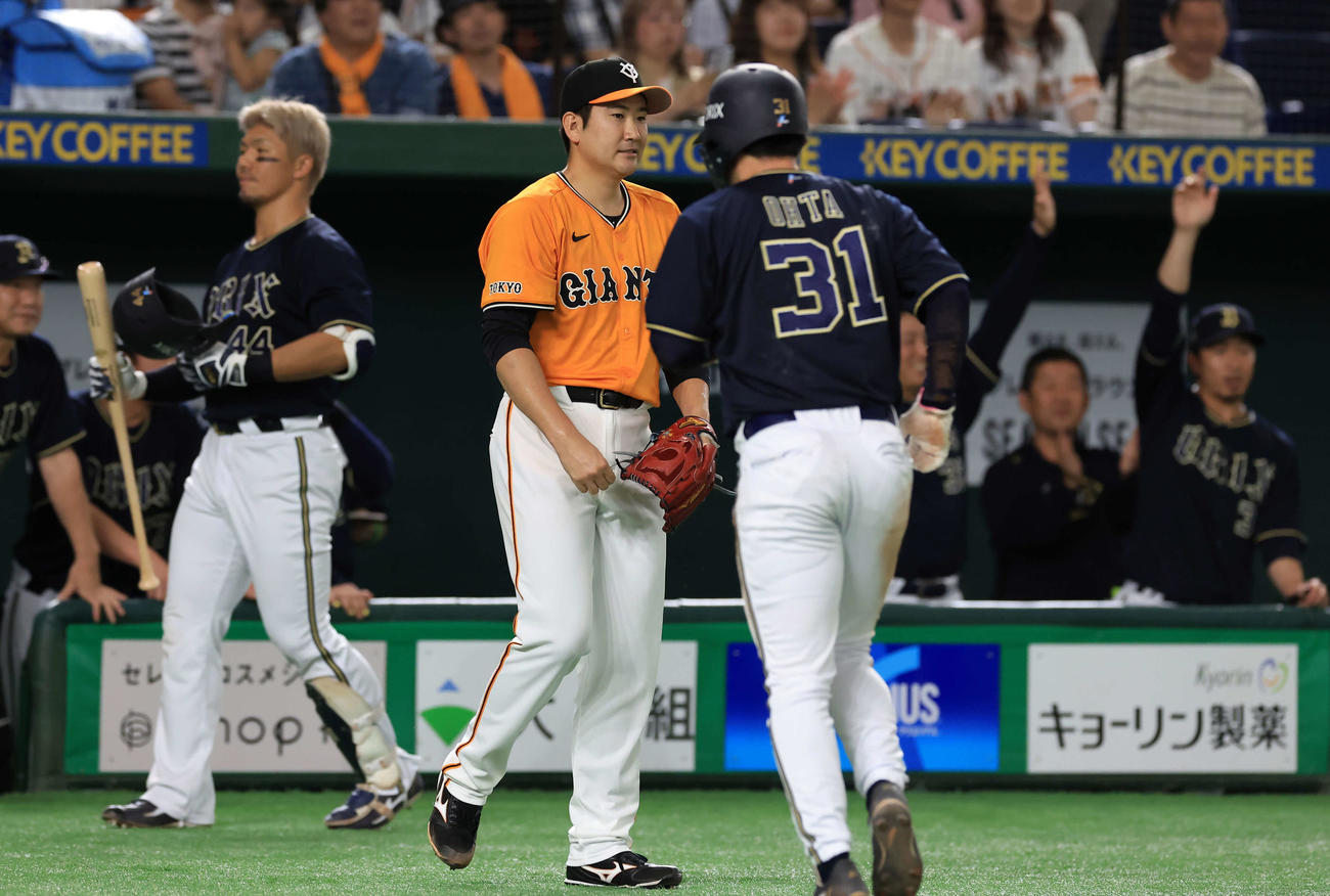 巨人対オリックス　3回表オリックス1死一塁、西川に右越え適時二塁打を許し、喜ぶオリックスベンチを背に悔しそうな菅野（中央）（撮影・浅見桂子）