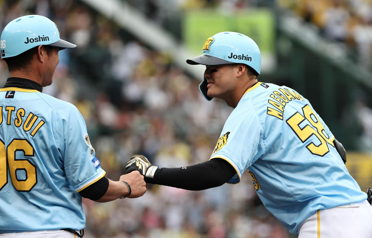 阪神対西武　7回裏阪神2死三塁、前川は右前に適時打を放ち、筒井コーチとタッチ（撮影・西尾就之）