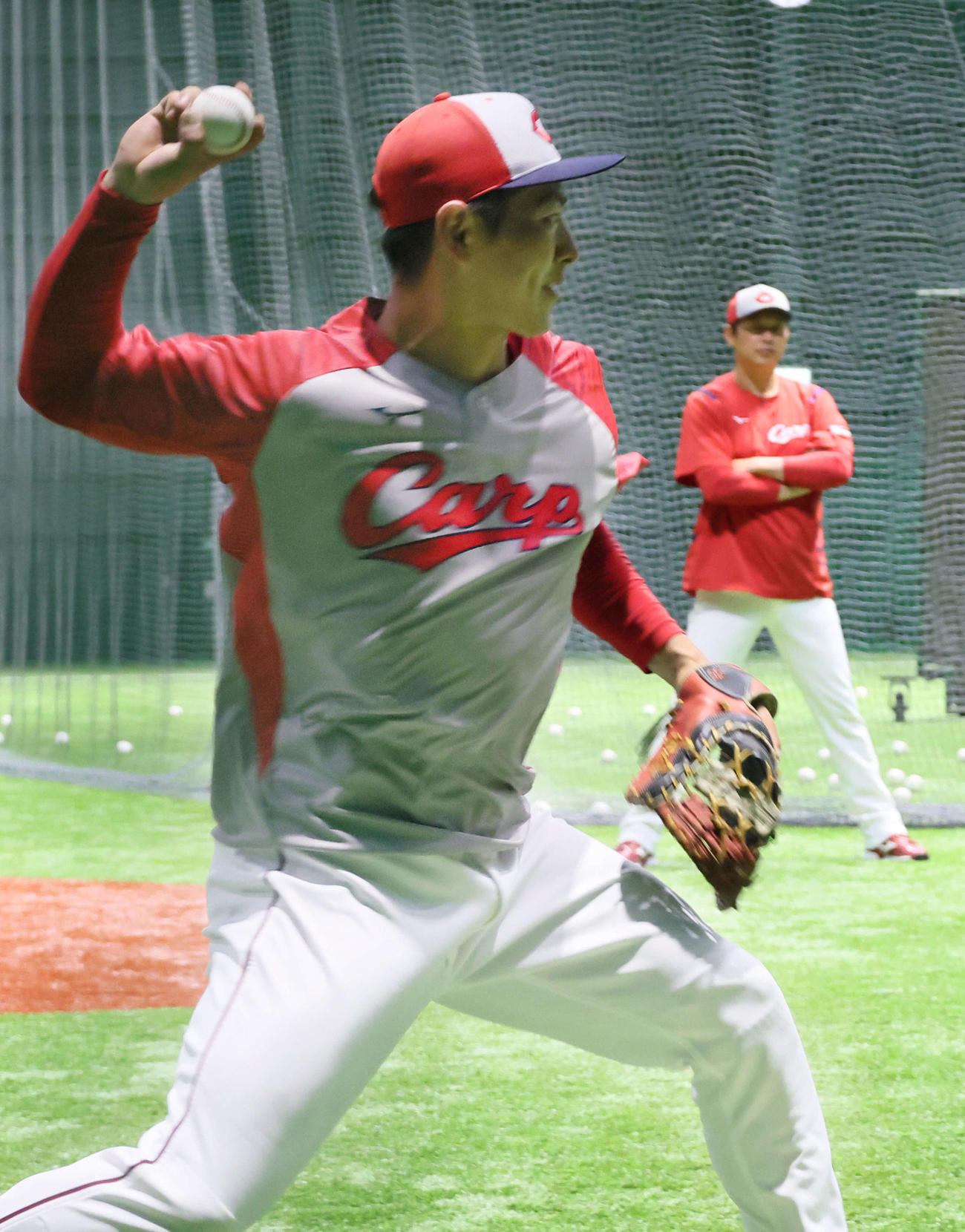 広島対ロッテ　支配下登録された佐藤（左）は試合前、新井監督が見守る中、ノックを受ける（撮影・加藤孝規）
