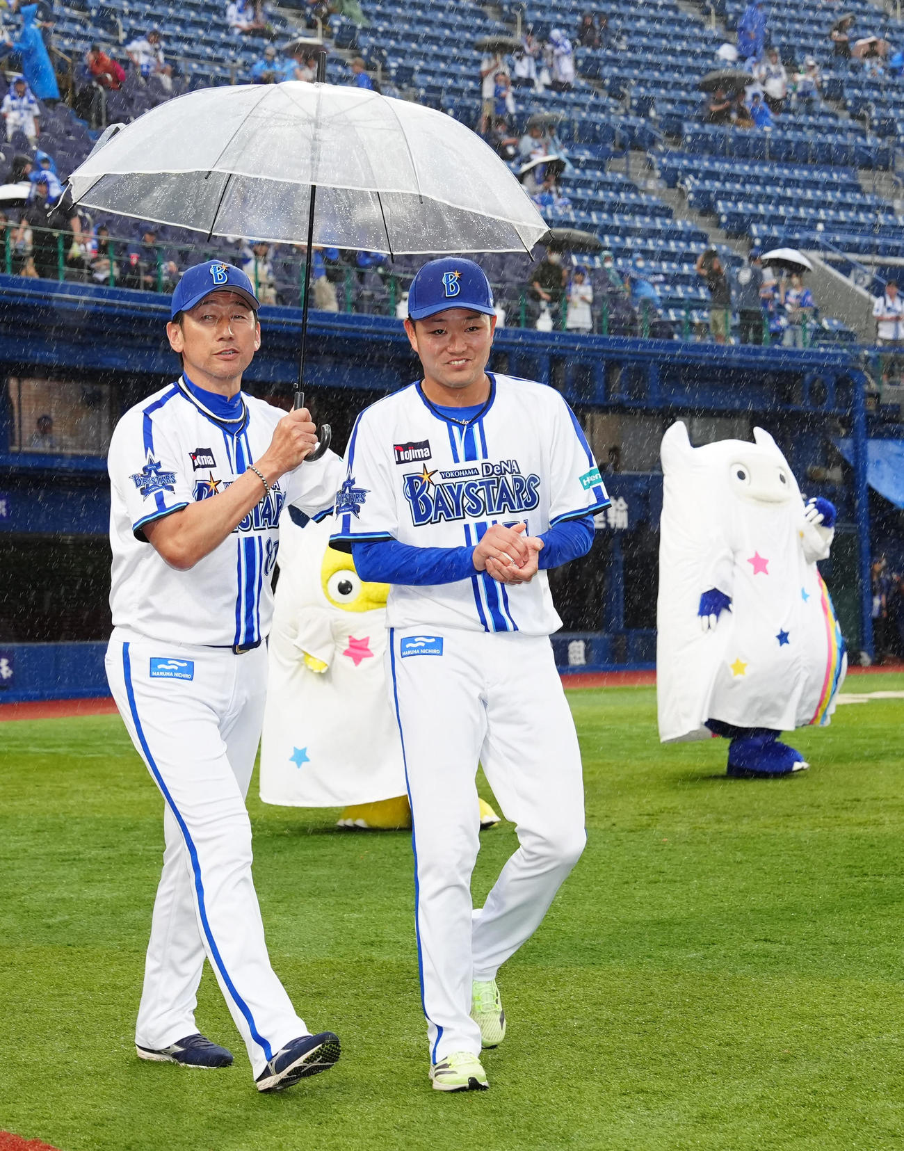 DeNA対ソフトバンク　試合後、降雨でDeNA三浦監督（左）がさす傘に入れてもらう石田裕（撮影・江口和貴）