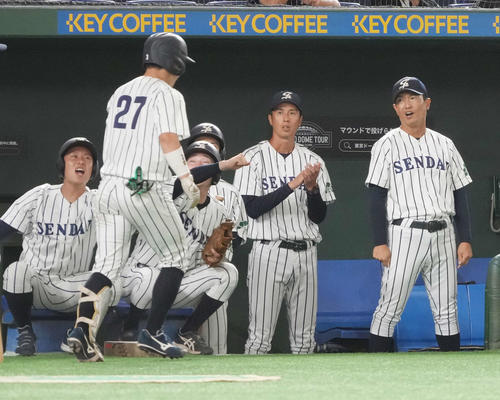 星槎道都大対仙台大 3回裏仙台大無死二、三塁、遊ゴロで先制点を奪った井尻(左)はベンチのナインの祝福を受ける(撮影・小沢裕)