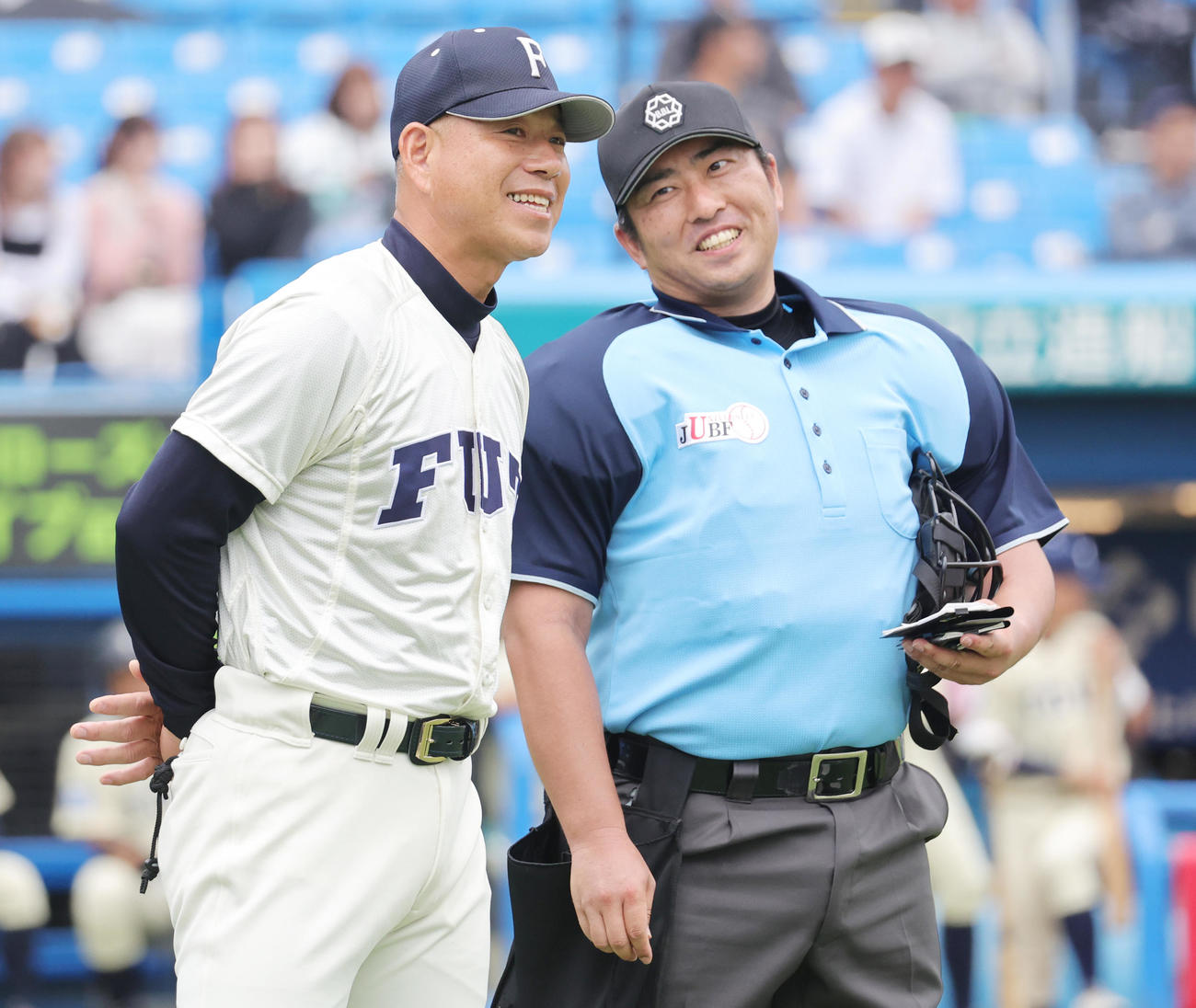 福井工大対桐蔭横浜大　佐伯球審（右）に選手交代を告げる福井工大・町田監督（撮影・野上伸悟）