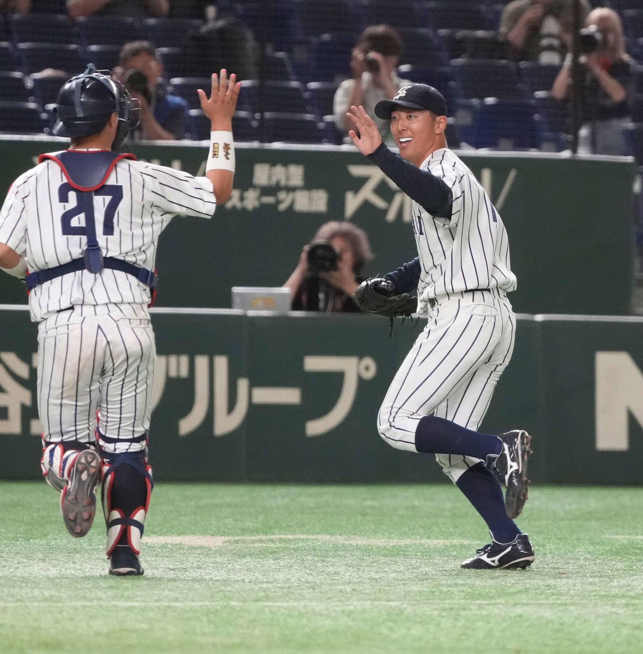 槎道都大対仙台大　5回表星槎道都大2死三塁、仙台大先発の渡辺はこの回を無失点でしのぎ井尻（左）とハイタッチ（撮影・小沢裕）