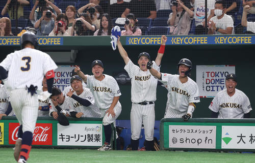 東日本国際大対吉備国際大　8回表東日本国際大2死満塁、黒田（左端）は右中間に逆転満塁本塁打を放ち歓喜するナインが出迎えを受ける（撮影・柴田隆二）