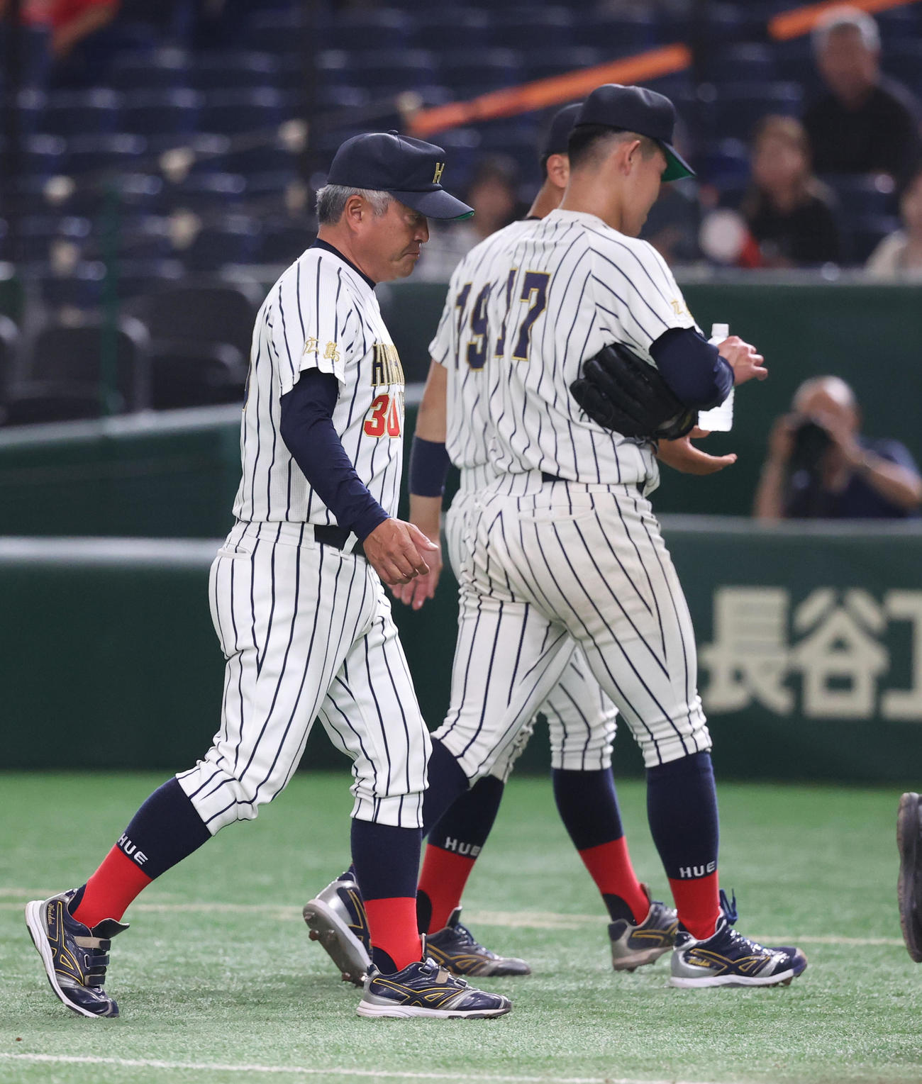 広島経大対和歌山大　5回途中でベンチに治療のため戻る広島経大・安岡（右）（撮影・柴田隆二）