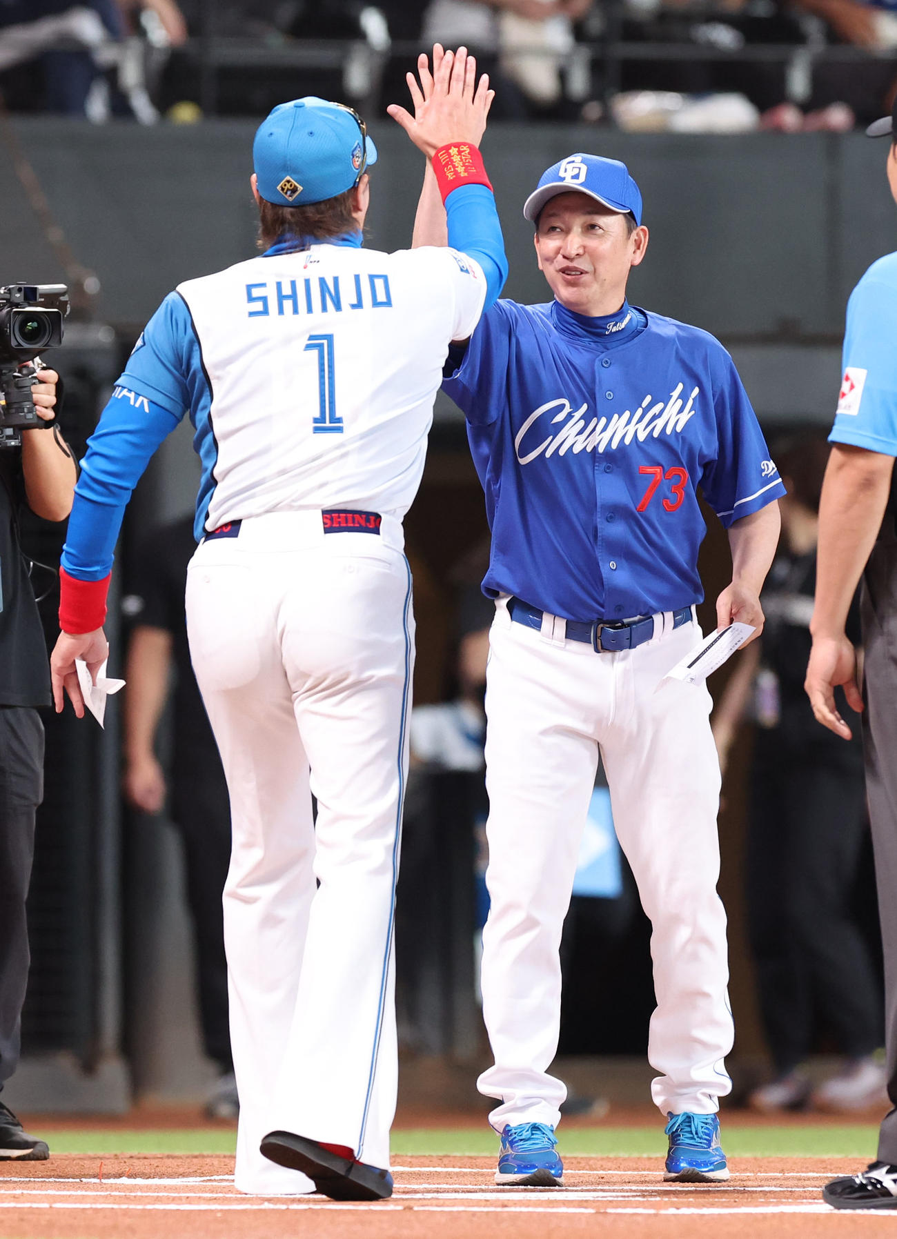 日本ハム対中日　試合前、メンバー表を交換しハイタッチをする日本ハム新庄監督（左手前）と中日立浪監督（撮影・佐藤翔太）