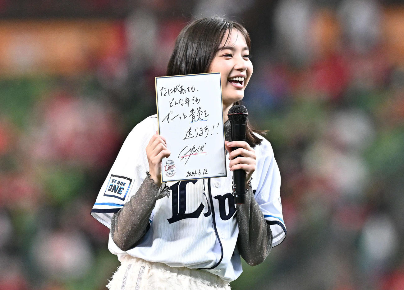 西武対広島　始球式に臨む新川優愛は「なにがあっても、どんな年でもずーっと青炎を送ります！！」と記した色紙を手にする（撮影・滝沢徹郎）