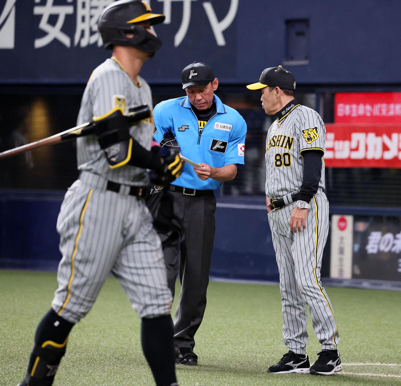 オリックス対阪神　7回表を終え選手交代を告げる岡田監督。左は三振してベンチへ戻る佐藤輝（撮影・加藤哉）