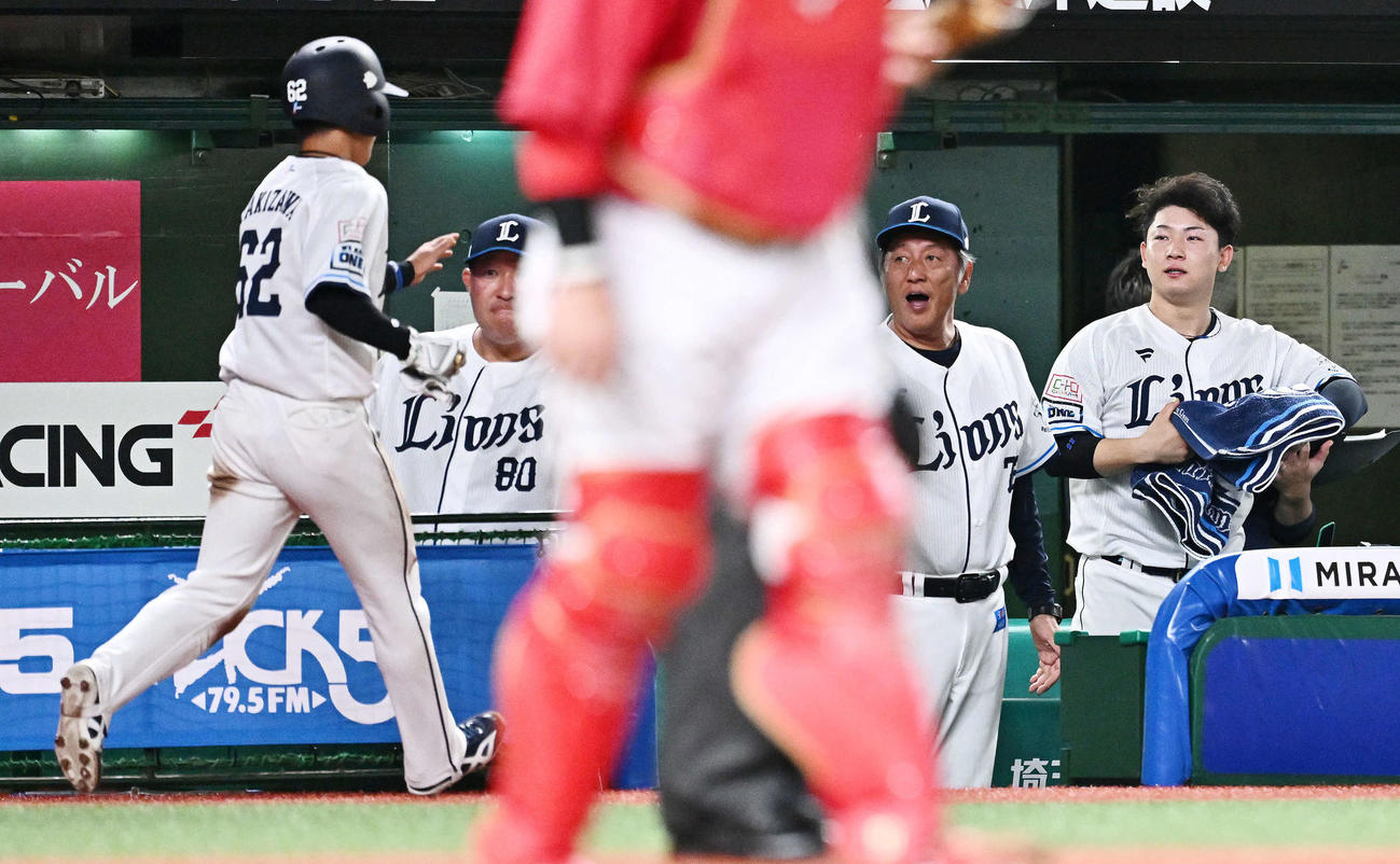 西武対広島　5回裏西武2死三塁、元山の先制適時打で生還した滝沢（左）を迎える渡辺GM兼監督代行（左から3人目）（撮影・滝沢徹郎）