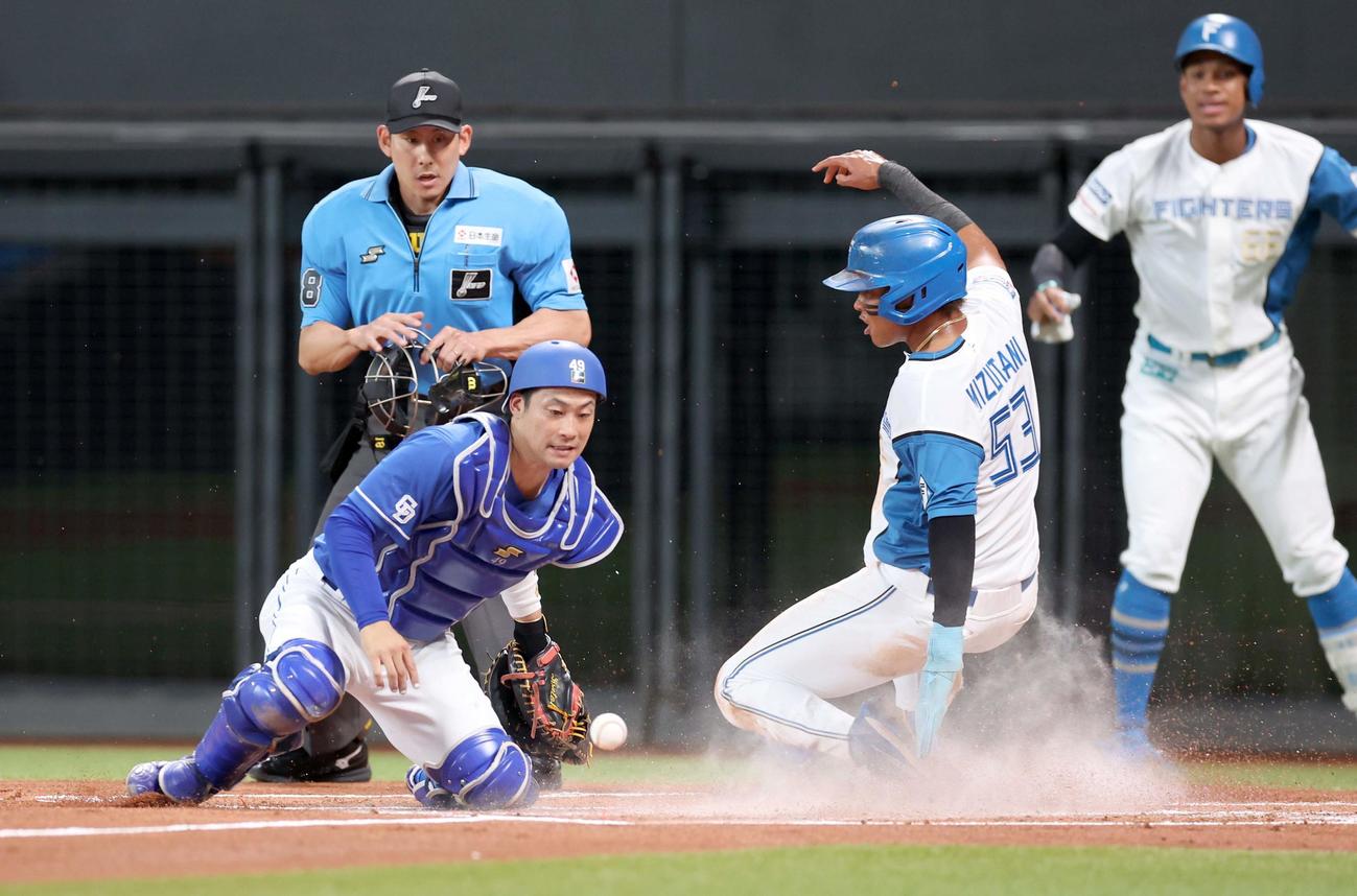 日本ハム対中日　1回裏日本ハム2死一、二塁、田宮の右前適時打で生還する水谷。捕手加藤匠（撮影・黒川智章）