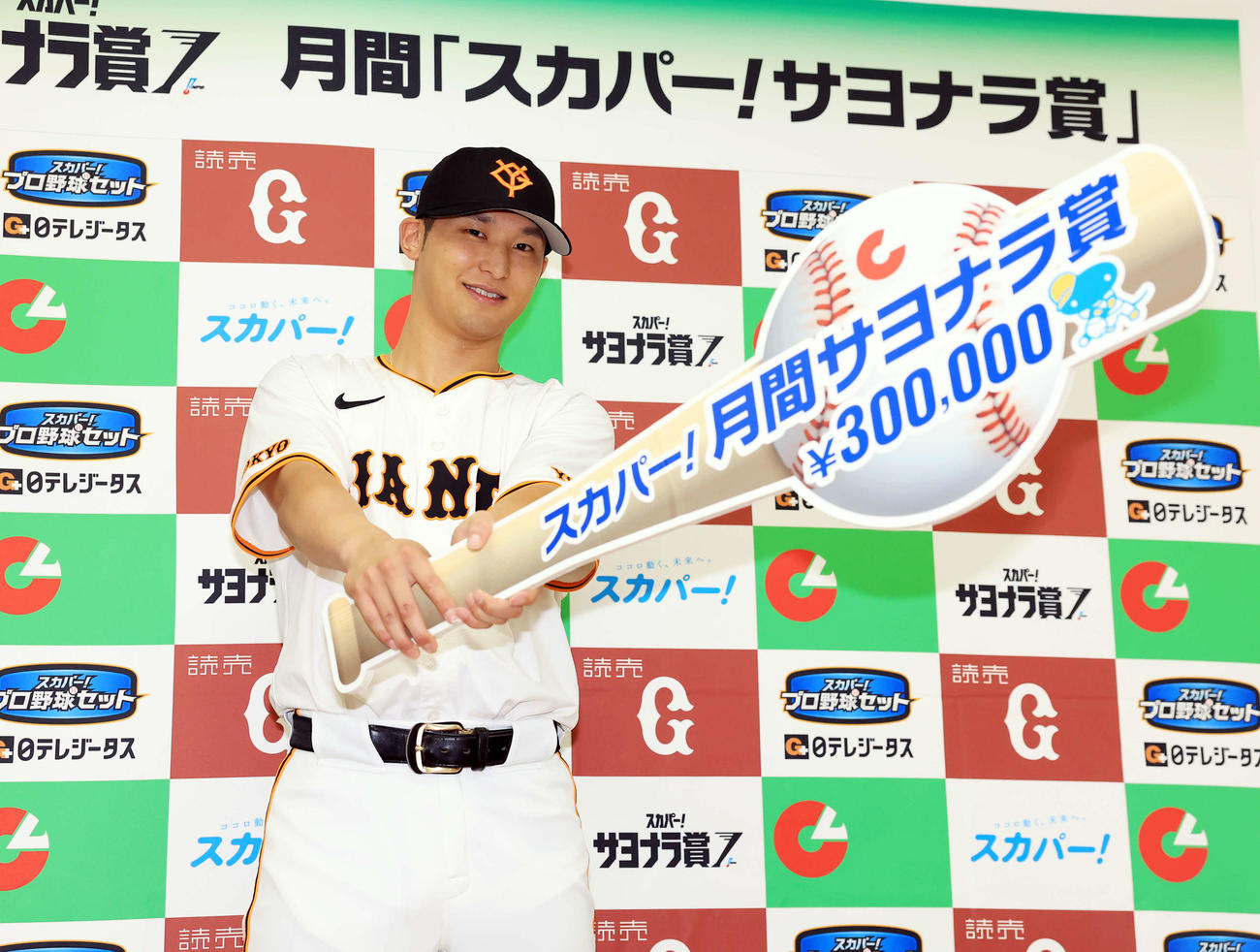 月間スカパー！サヨナラ賞を受賞した巨人吉川はバット型ボードを手に笑顔を見せる（撮影・浅見桂子）