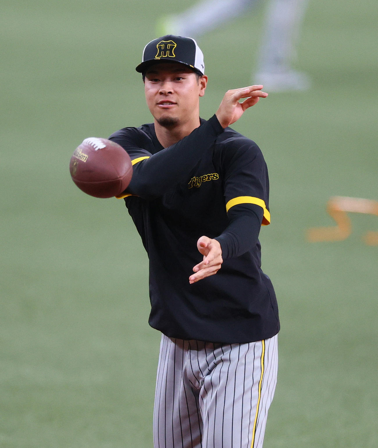 オリックス対阪神　試合前、リラックスした表情でアメフトのボールを投げる阪神佐藤輝（撮影・上山淳一）
