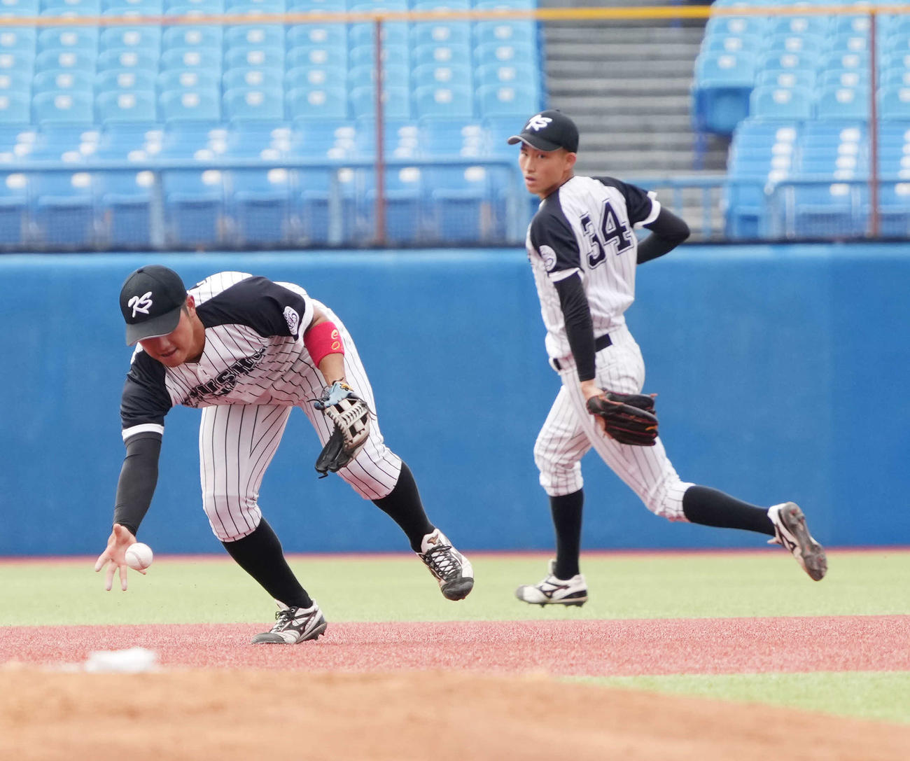 九産大対早大　2回裏早大2死三塁、九産大・市丸三塁手（左）は石郷岡の三ゴロをはじき先制の適時失策とする（撮影・小沢裕）