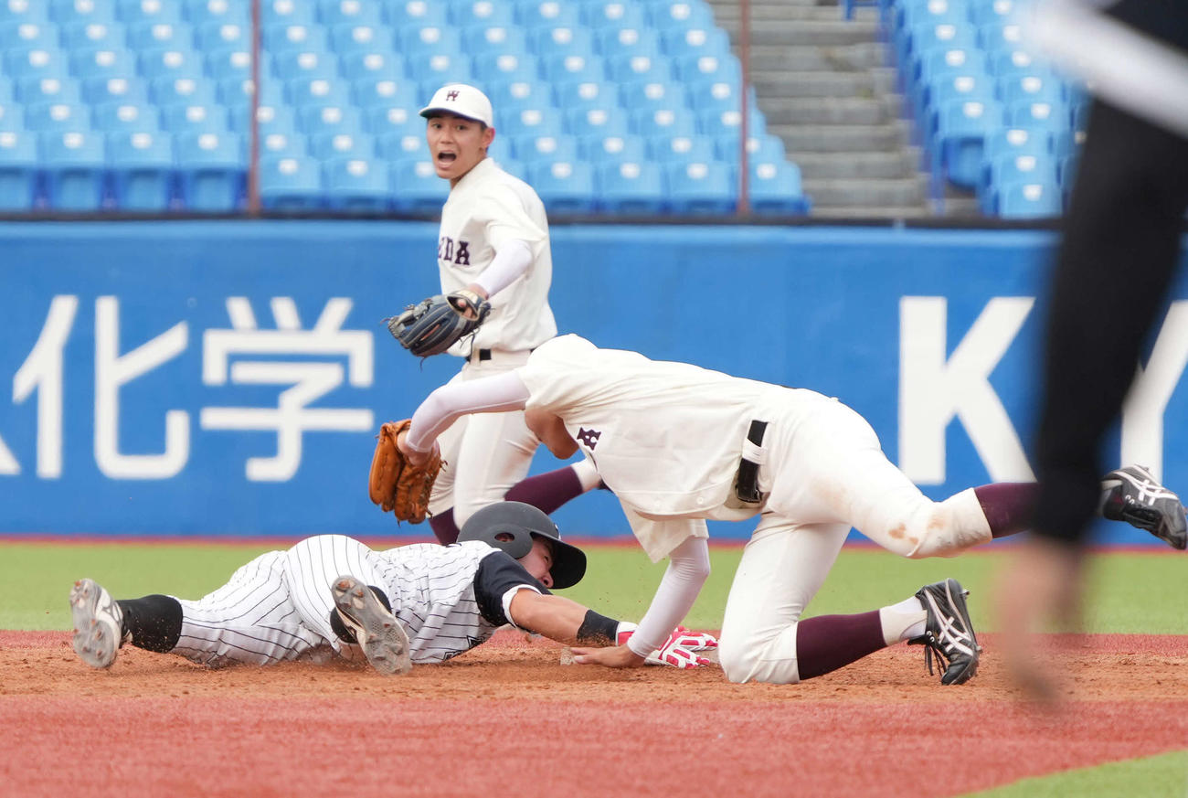 九産大対早大　4回表九産大2死二塁、二塁走者の松尾（左）は早大・印出捕手のけん制でタッチアウト（撮影・小沢裕）