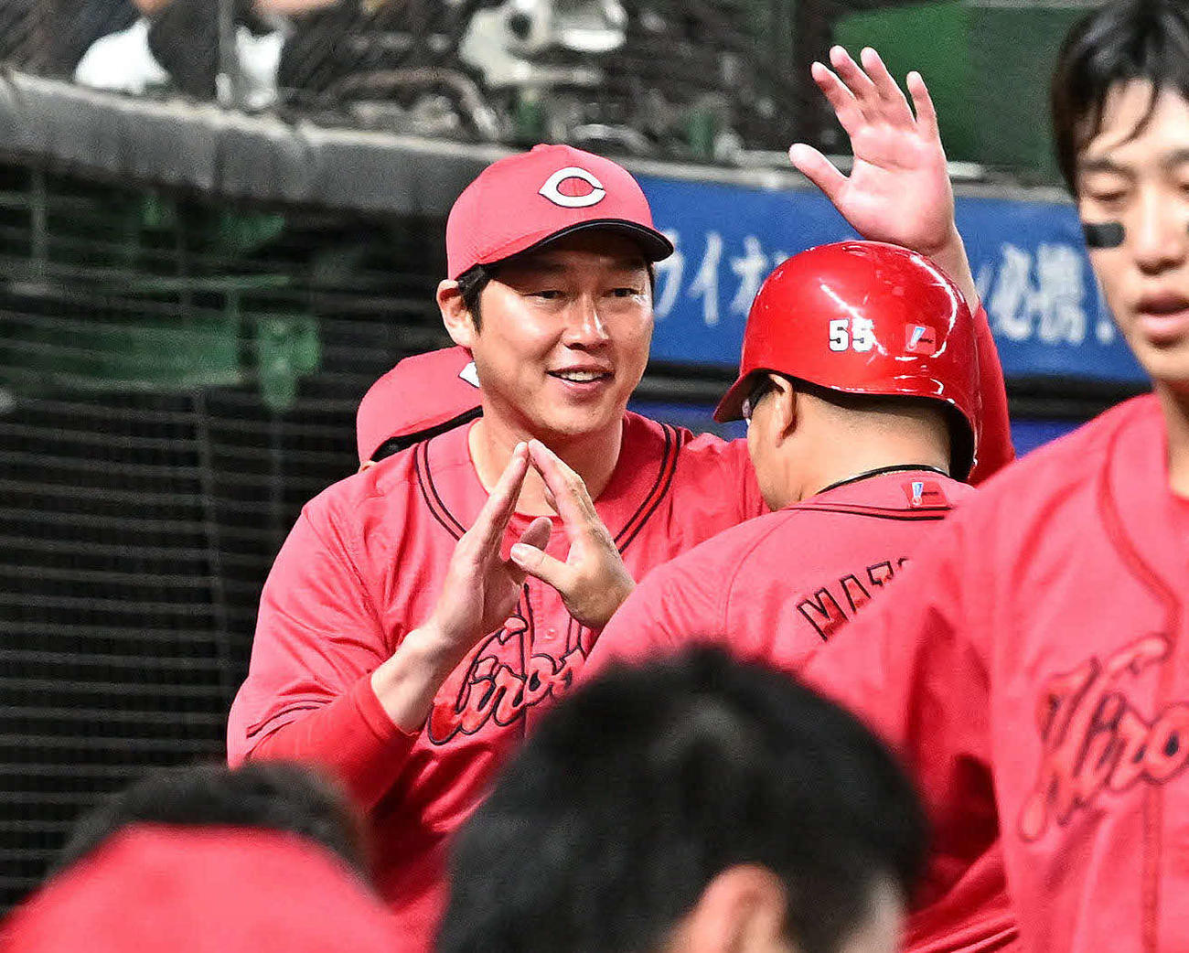 西武対広島　7回表、広島新井監督（右後方）は2点適時二塁打を放った松山を迎える（撮影・滝沢徹郎）