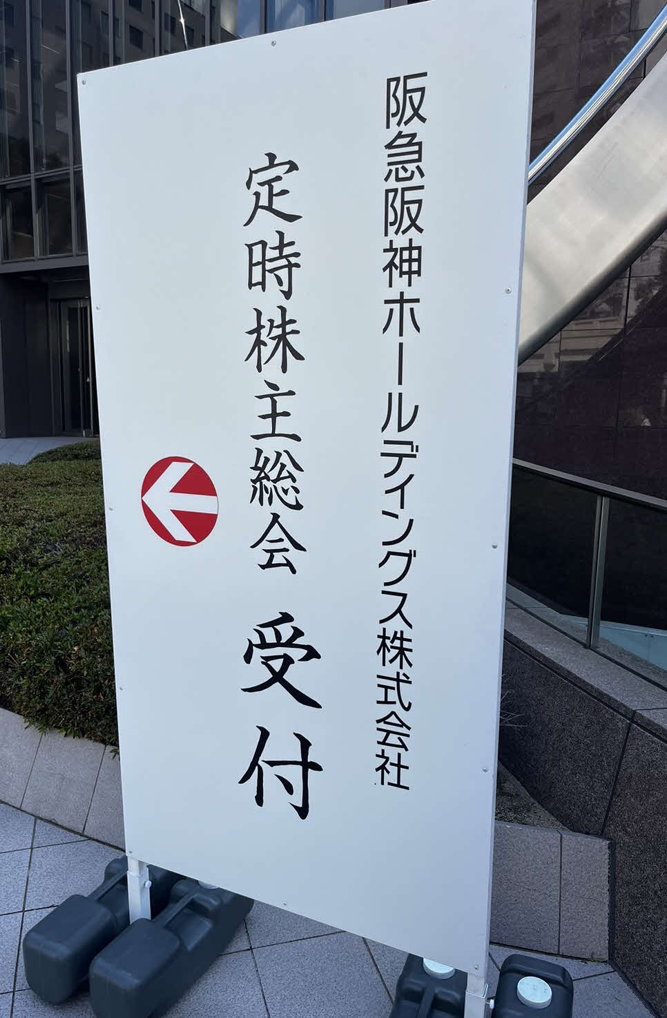 大阪市内で開催された阪急阪神ホールディングス株式会社の定時株主総会の受付と明記された看板（撮影・中野椋）