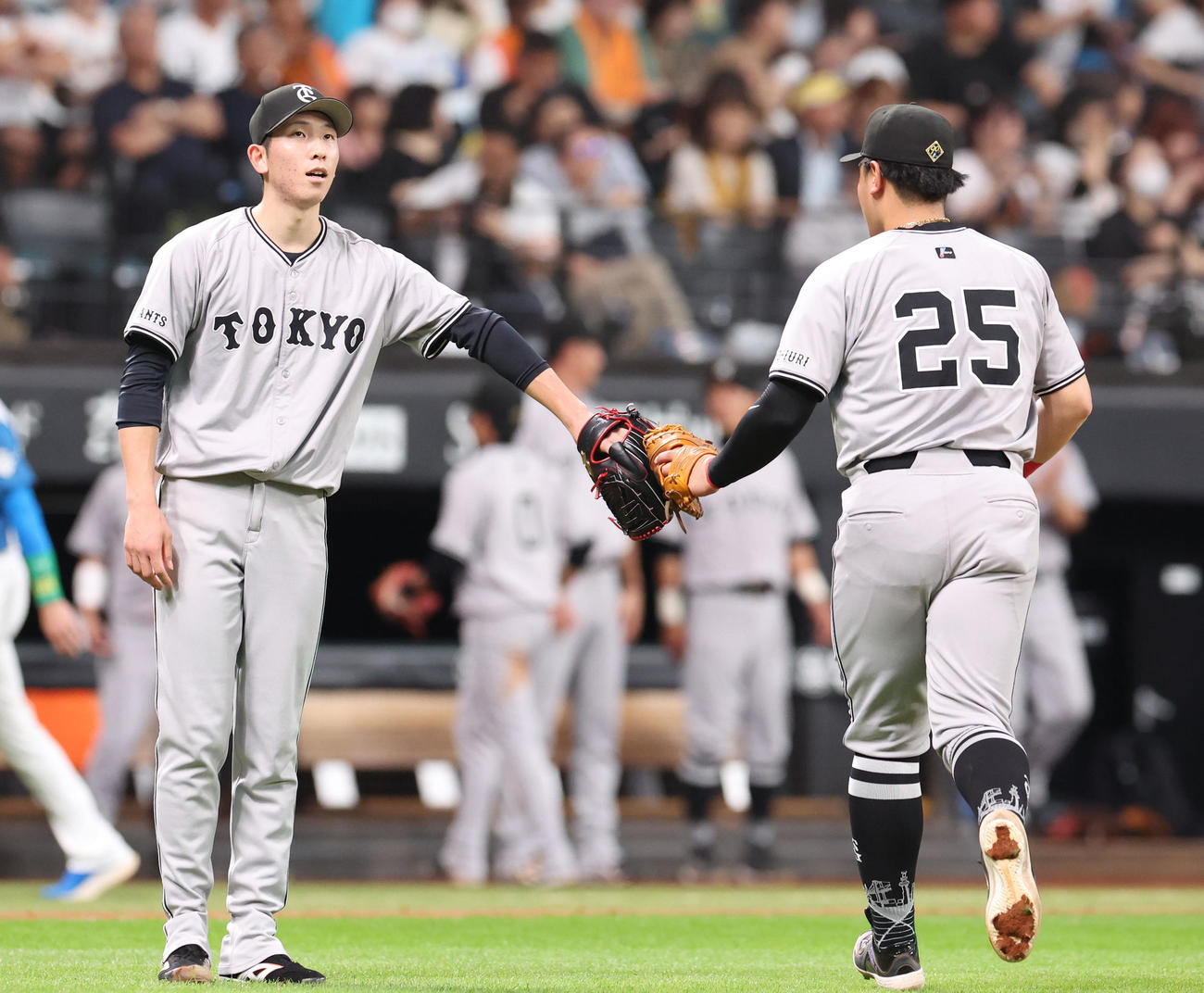 日本ハム対巨人　5回裏を無失点に抑えタッチしながらベンチに戻る戸郷（左）と岡本和（撮影・佐藤翔太）