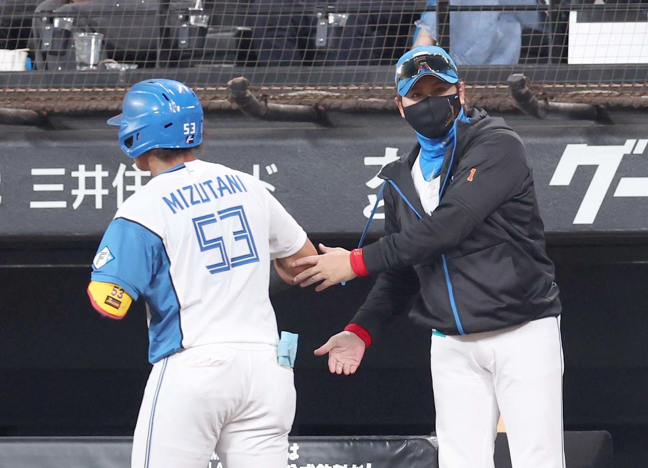 日本ハム対巨人　4回裏、本塁打を放った水谷を出迎える新庄監督（撮影・黒川智章）