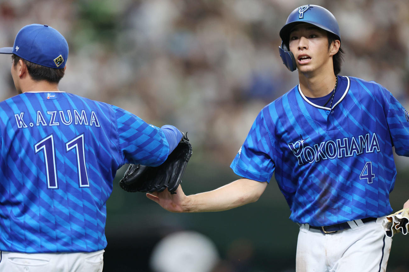 西武対DeNA 5回表DeNA1死三塁、中前適時打を放った度会（右）はベンチに帰る際、東とタッチする（撮影・宮地輝）