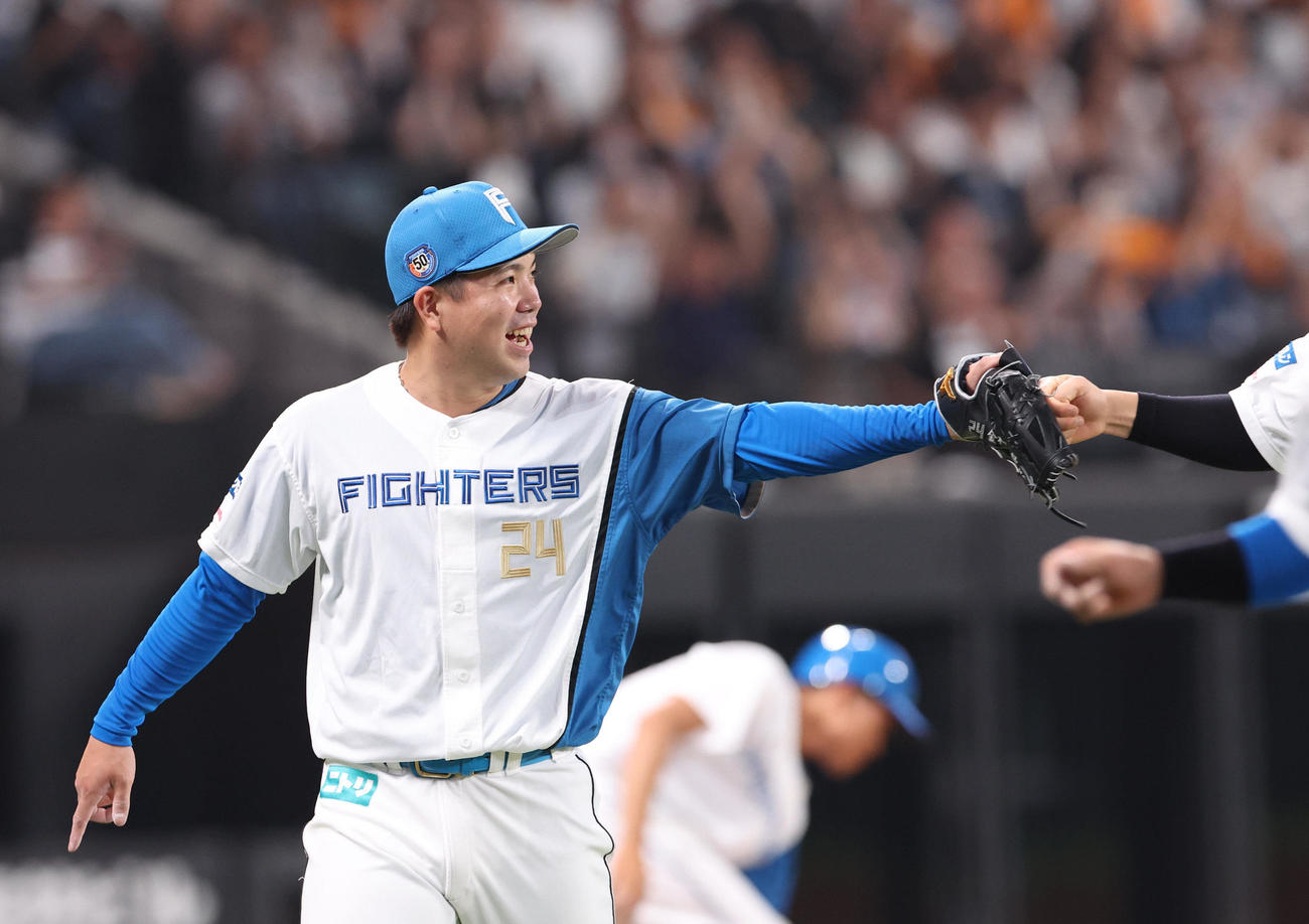 日本ハム対巨人　7回表巨人1死満塁、坂本を併殺打に仕留め笑顔でナインとともにベンチに戻る金村（撮影・佐藤翔太）