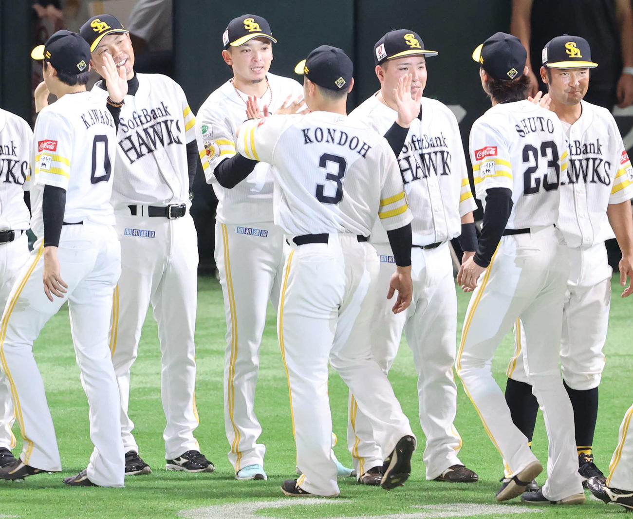 ソフトバンク対阪神　ハイタッチで近藤らナインを出迎える小久保監督（左から2人目）と東浜（同3人目）ら（撮影・梅根麻紀）