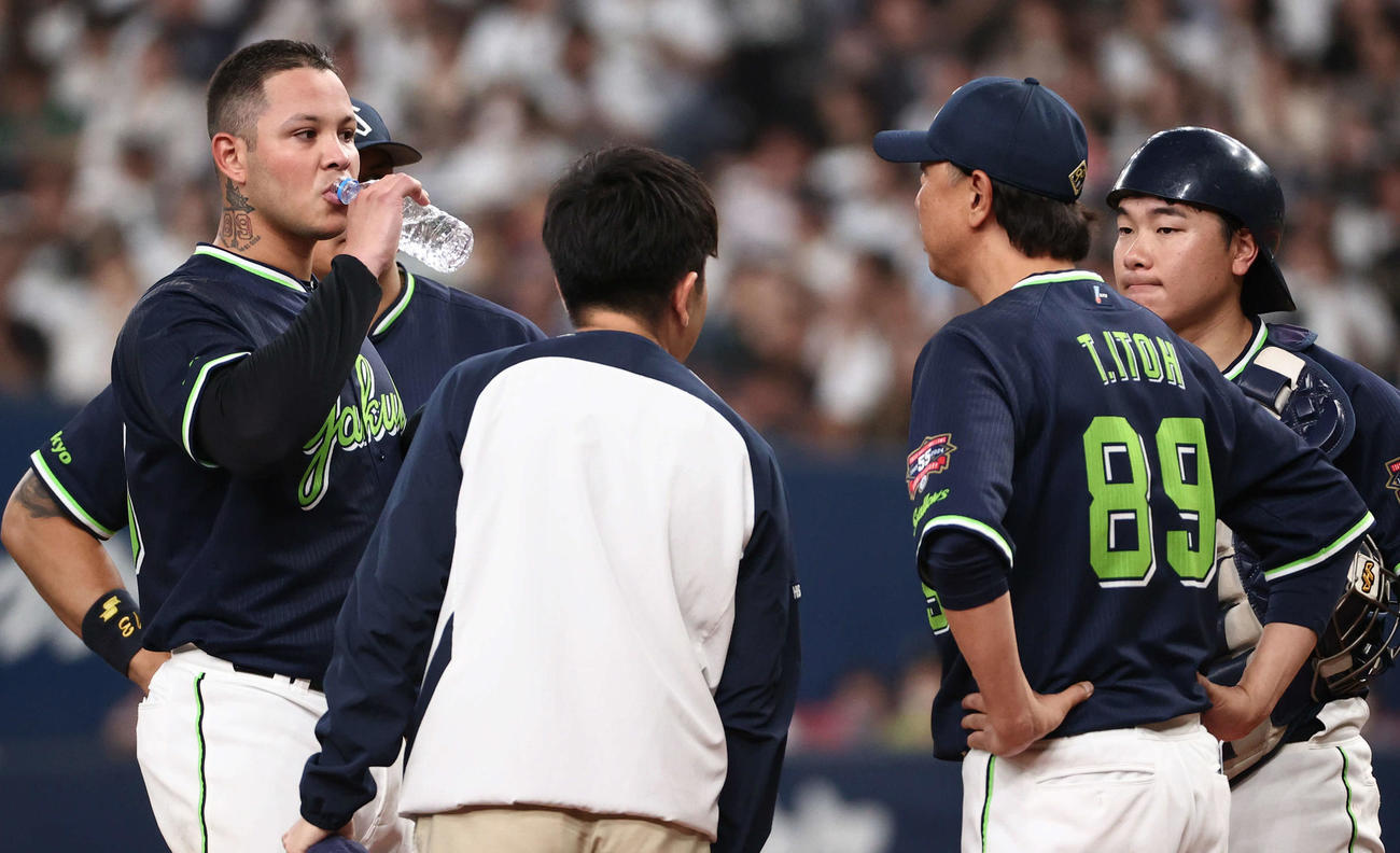 オリックス対ヤクルト　5回裏オリックス1死一、二塁、太田に適時二塁打を打たれたヤフーレは水分を補給しながら伊藤コーチの指示を聞く（撮影・西尾就之）